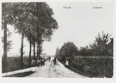 0362-173 Zandstraat met op voorgrond 2 fietsers en een groepje kinderen