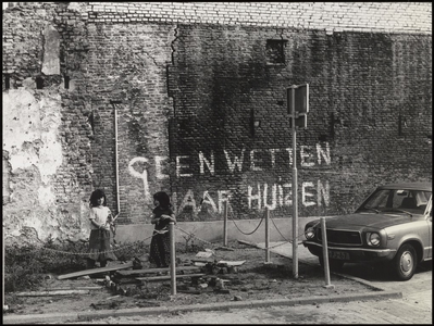 580 Een aanzicht van een parkeerplaats nabij de Kerkstraat in Tiel. Op de foto enkele spelende kinderen voor een oude ...