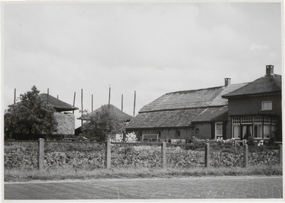 M 11922 Een boerderij in Ommeren met aan de achterzijde twee bergen voor de opslag van koren