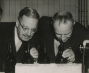 M 184 Burgemeester Cambier van Nooten (links) controleert hier de geur van waarschijnlijk wijnflessen, mogelijk bij De Betuwe