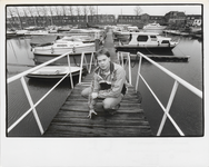 M 7259 Foto van een jongeman op de loopplank in de haven van Culemborg met op de achtergrond de Veerweg met woonhuizen