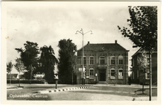 1228 Een prentbriefkaart van het oude gemeentehuis in Opheusden met rechts daarvan een deel van de pastorie
