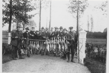 0362-1189 Jagers en vangstdragers poseren trots met hun buit aan hazen en gevogelte bij toegangshek Huize 't Schild