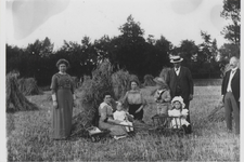 0362-1208 Fam. Verbrugh met o.a. kinderen tussen korenschoven in korenveld. Op achtergrond de heg van Huize Kortenhoeve