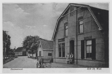0362-1227 Twee dienstbodes poseren voor de ingang van tegenwoordige slagerij Ter Haar. In de verte de schuur van café ...