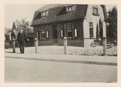 0362-531 Persoon poseert voor woonhuis aan Tielsestraat na aanleg van riolering en trottoir