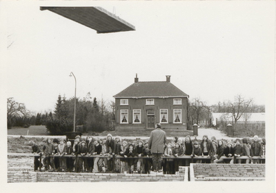 0362-558 Roelof Veldhuizen spreekt schoolkinderen toe voor de in aanbouw zijnde basisschool. Op achtergrond T-boerderij ...
