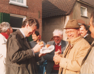 Lie 395 Bezoek Wim Kok in teken van Tweede Kamerverkiezingen. De heer Kok met een op een lunchpakket lijkend ...