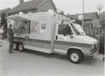 0369-218 burgemeester Harinck levert KCA-box in bij inzamelwagen op het Dorpsplein