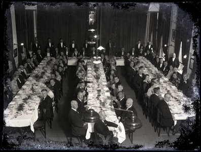 52 Groepsfoto van een groot gezelschap van mannen en vrouwen, aangezeten bij een diner in het Spaarbankgebouw (?)