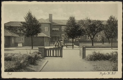 H 11.7 HBS (later Regionale Scholengemeenschap Lingecollege te Tiel) vanaf de Heiligestraat gezien met de ingang. ...