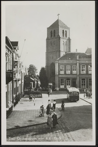 K1.4 Vooraanzicht van het Gymnasium en de toren van de St. Dominicuskerk. De autobus van de streekvervoerder. Vooraan ...