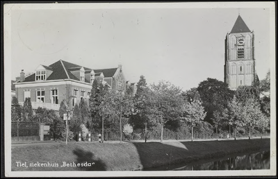 K 9.24 Kastanjelaantje Tiel: Achtergevel en tuin, met hek, van Bethesda ziekenhuis, Rechts de toren van Sint ...
