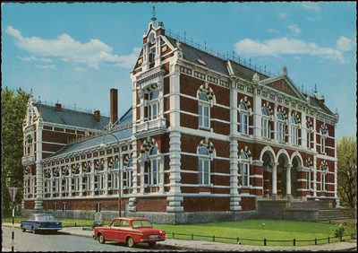 N 4.46 Voor- en linkerzijgevel van het Gerechtsgebouw. Er staan auto's in de Kwelkade.