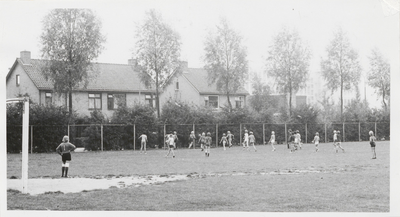 M 10722 Sportveld bij sporthal aan Cambier Van Nootenlaan. Op de achtergrond huizen aan de Burgemeester Schullstraat