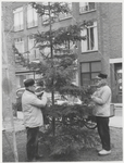 M 11106 Twee gemeentewerkers bezig met het neerzetten van een kerstboom op het Plein