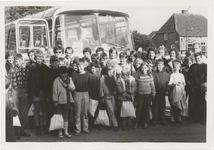M 11121 Groep schoolkinderen en begeleiders staand voor een bus