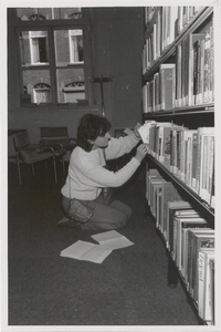 M 11482 De bibliotheek aan de Sint Agnietenstraat 28 in Tiel voor de verbouwing van 1987. Een jonge vrouw neemt een ...