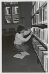 M 11482 De bibliotheek aan de Sint Agnietenstraat 28 in Tiel voor de verbouwing van 1987. Een jonge vrouw neemt een ...