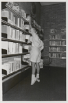 M 11495 De bibliotheek aan de Sint Agnietenstraat 28 in Tiel voor de verbouwing van 1987. Een kind pakt een boek uit ...