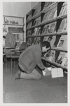 M 11497 De bibliotheek aan de Sint Agnietenstraat 28 in Tiel voor de verbouwing van 1987. Een man zit op zijn knieen ...