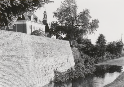 M 11635 Het water staat tegen de voet van de stadsmuur in Tiel. Op de achtergrond het museum en de Waterpoort