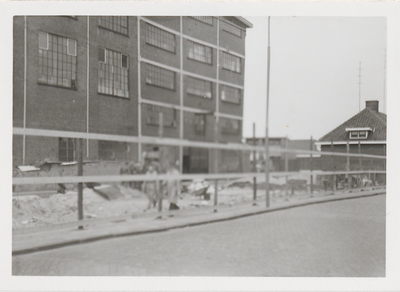 M 11734 Tijdens het vernieuwen van de schutting bij het fabrieksgebouw van Daalderop aan de Grotebrugse Grintweg, maart 1962