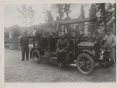 M 11779 Leden van het brandweerkorps (reddingsbrigade) en enkele brandmeesters poseren met hun 1ste motorspuit voor de ...