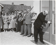 M 12135 Een burgemeester verricht een openingshandeling door met een sleutel een deur te openen