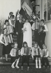 M 1293 Een lid van de accordeonvereniging Mondagita treedt in het huwelijk. Op de foto het bruidspaar omringd door ...