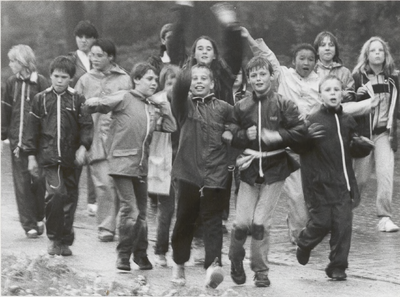 M 1932 Kinderen wandelen in de regen tijdens de Avondvierdaagse