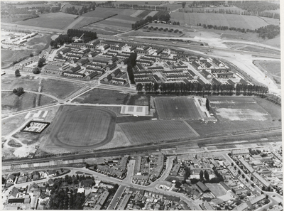 M 208 Luchtfoto van Tiel. Onder het midden de spoorlijn Tiel-Kesteren. Daarboven het veldencomplex van T.E.C. Boven de ...