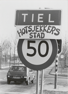 M 2210 Bord Hotsjekkerstad onder naambord Tiel van de carnavalsvereniging De Hotsjekkers 