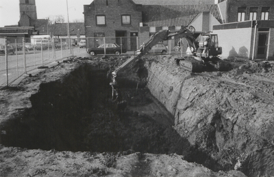 M 2965 Aan de Kloosterstraat is een graafmachine bezig met het graven van een gat in de grond voor de aanleg van de ...