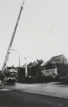 M 3051 Links op de foto hijst een hijskraan van de firma Schiltmans uit Tiel dakmateriaal op naar een van de daken van ...