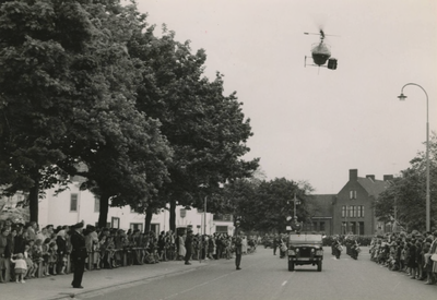 M 329 Het defile van militairen op de Veemarkt, een helicopter vliegt mee