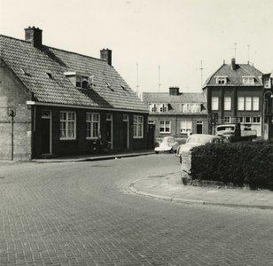 M 34 Een foto van een rijtje woningen tegenover de hoek Nieuweweg met de Brugstraat