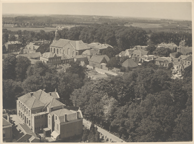 35 De Wilhelminaschool en de in 1938 afgebrande katholieke kerk, gefotografeerd vanaf de Sint- Maartenskerk. Midden ...