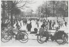 M 4424 Op de bevroren stadsgracht nabij de Veemarkt (links) zijn veel mensen aan het schaatsen. In het midden op de ...