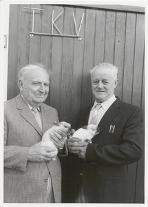 M 5058 Twee mannen met twee jonge konijntjes bij de Tielse Kleindieren Vereniging