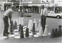 M 5064 Inwijding schaakspel promenade Groenmarkt. Op de foto bekijken een paar middenstanders (?) het schaakspel dat is ...