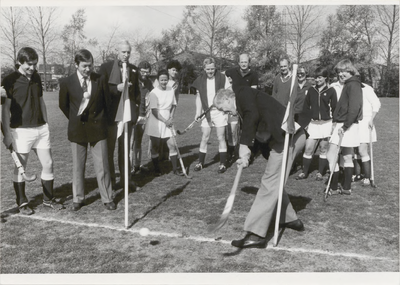 M 5422 Wethouder Van den Burg slaat een bal bij de Tielse hockeyers