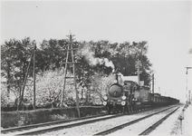 M 6130 Op de foto een spoorbaan met een rijdende locomotief en goederenwagons