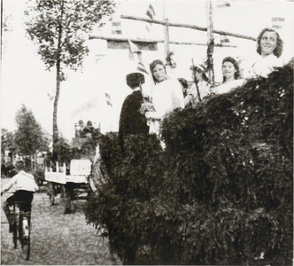 M 6258 Bevrijdingsoptocht tijdens Oranjefeest, dames boven op de wagen