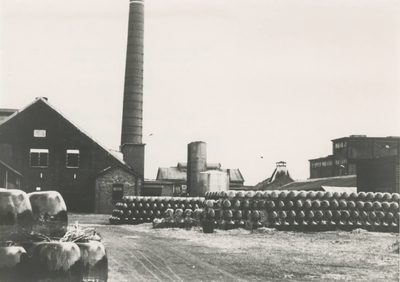 666 Het terrein van de Fa. Verdugt met op de voorgrond opgeslagen demyohns.Tiel, jaren zestig.