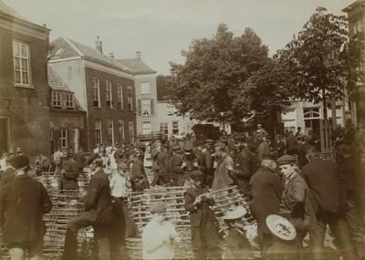 704 De Varkensmarkt. In de manden worden de varkens aangevoerd en verhandeld. Geheel links is een gedeelte te zien van ...