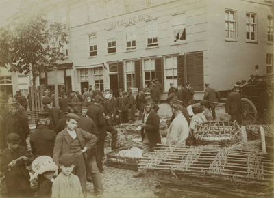 705 De Varkensmarkt. Boven het midden staat het Hotel de Zon, waarvan de eigenaar De Goeij heet. Geheel links is het ...