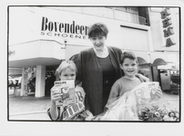M 7244 Waarschijnlijk een moeder met twee kinderen voor de winkel van Bovendeert schoenmode, de kinderen hebben een ...