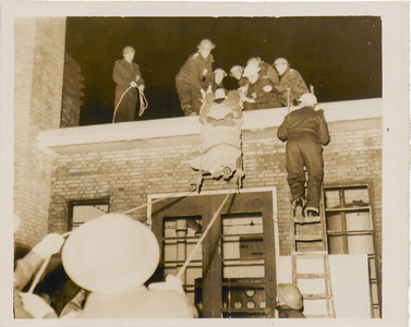 M 7381 Foto van een oefening van de B.B. (Bescherming Bevolking) waarbij gewonden per brancard van het dak van het ...