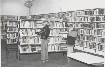 M 8196 Interieur Tielse leeszaal en bibliotheek, St. Agnietenstraat 28, twee jonge bezoekers bekijken boeken